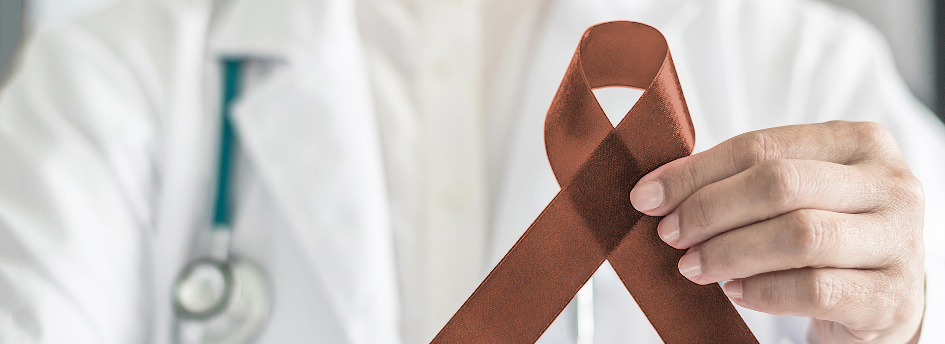The image shows a person holding an AIDS awareness ribbon with a medical professional in the background wearing a stethoscope.