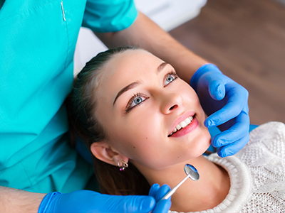 A woman receiving dental treatment with a dentist performing the procedure.